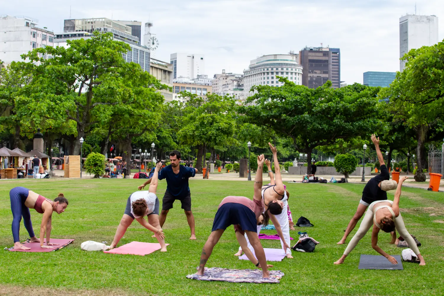 Grupo praticando yoga ao ar livre na grama da Praça Paris, na Glória
